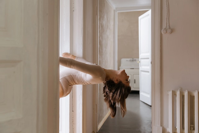 een danseres hangt half ondersteboven in een open deur